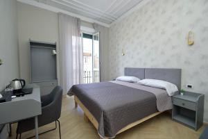 ローマにあるRohome Stayのベッドと机と窓のある寝室