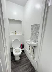 a white bathroom with a toilet and a sink at Lovely Guest House in Kent
