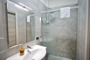 ローマにあるRohome Stayの洗面台と鏡付きシャワーを備えたバスルーム