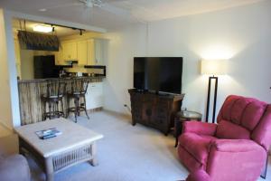 a living room with a couch and a tv at Kona Pacific C319 in Kailua-Kona