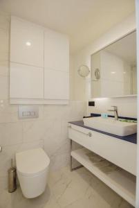 Orbi City Apartments Batumi في باتومي: حمام مع مرحاض ومغسلة ومرآة