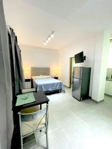 een kamer met een bed, een bureau en een keuken bij Latorre Apartment in Salta