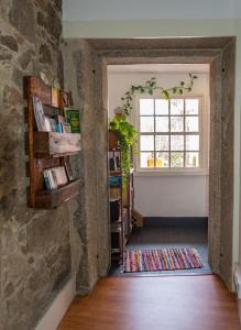 una camera con una parete in pietra e una finestra di inBraga Hostel a Braga