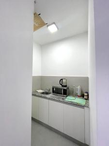 een keuken met witte kasten en een magnetron bij Latorre Apartment in Salta
