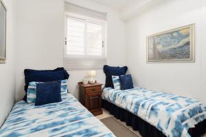 a bedroom with two beds with blue and white sheets at Colonial Sands 403 in Margate