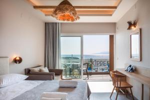 a bedroom with a bed and a view of the ocean at Skipper Beachfront Suites in Hersonissos