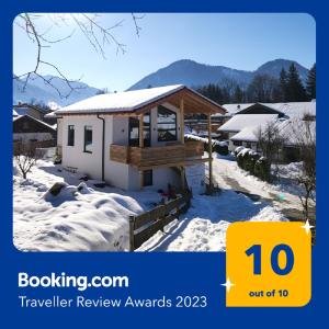 a small house with snow on the ground at Fuxbau Waldlounge in Ruhpolding