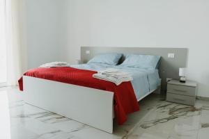 - une chambre blanche avec un lit et une couverture rouge dans l'établissement CASALMARE, à Casalbordino