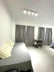 een slaapkamer met een bed en een tafel. bij Latorre Apartment in Salta