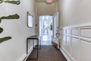 a hallway with a table and an open door at Sosuite at French Quarters - Rittenhouse Square in Philadelphia
