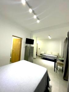 een witte slaapkamer met een bed en een koelkast bij Latorre Apartment in Salta