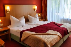 una habitación de hotel con una cama grande con paredes rojas en Landgasthof Allerparadies, en Langlingen