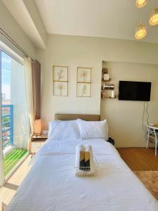 1 dormitorio con 1 cama blanca grande y TV en 11F Condo in Limketkai Center CDO, en Cagayan de Oro