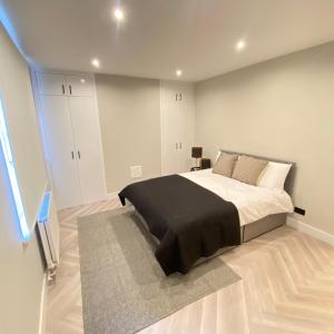 um quarto com uma cama grande e um cobertor preto em Luxury 2 bed 1 bath in Central London by Graceful Apartments em Londres