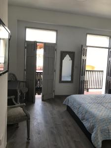 1 Schlafzimmer mit einem Bett, einem Schreibtisch und 2 Fenstern in der Unterkunft 310Guest-House La Vyda in San Juan