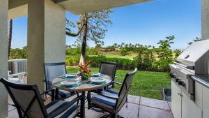 a table and chairs on a patio with a kitchen at Mauna Lani Fairways 903 in Waikoloa