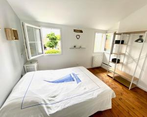 1 Schlafzimmer mit einem großen weißen Bett und 2 Fenstern in der Unterkunft LA MAISON DU BONHEUR in Rochefort