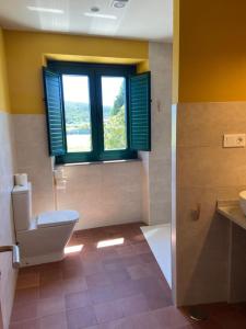 a bathroom with a toilet and a window at O TEU SITIO in Ribadeo