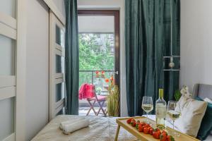 uma sala de estar com uma mesa com dois copos de vinho em Lumina apartments with balcony Warsaw em Varsóvia