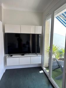 sala de estar con TV de pantalla plana grande en MAGNIFIQUE VUE MER Place Centrale F2 45 m2 tout confort Travaux en cours sur façade en Canet-en-Roussillon