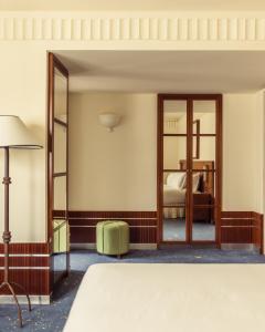 a bedroom with a bed and a mirror at Hôtel Des Grands Voyageurs in Paris