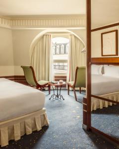 una camera d'albergo con due letti e una finestra di Hôtel Des Grands Voyageurs a Parigi
