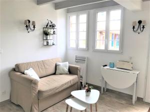 a living room with a couch and a table at LA MAISON DU BONHEUR in Rochefort +1 photo