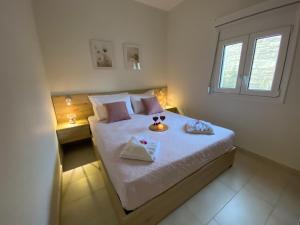 a bedroom with a bed with two trays on it at Maistro Suites with pool, Matala in Matala