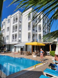 a woman in a bikini standing in front of a hotel pool at Esperanza Hotel in Antalya