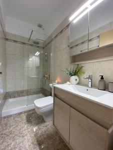 a bathroom with a sink and a toilet and a shower at Maistro Suites with pool, Matala in Matala