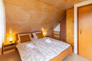 1 dormitorio con 1 cama en una habitación de madera en Počitniška hiša Uskovnica, en Srednja Vas v Bohinju