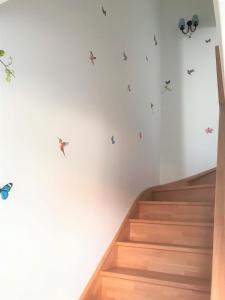 una escalera con calcomanías de mariposa en la pared en LA MAISON DU BONHEUR en Rochefort