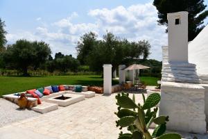 patio z kanapą i pomnikiem na dziedzińcu w obiekcie IL TRULLO BIANCO - Country House & SPA w mieście Castellana Grotte