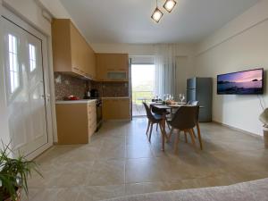 a kitchen and dining room with a table and chairs at Maistro Suites with pool, Matala in Matala