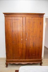 a wooden cabinet with wooden doors in a room at Mount Guest in Karagampitiya