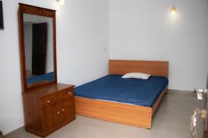 a bedroom with a bed and a mirror at Mount Guest in Karagampitiya