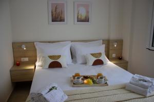 a bedroom with a bed with a tray of food on it at Maistro Suites with pool, Matala in Matala