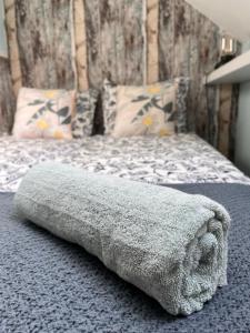 een grijze deken op een bed in een slaapkamer bij Apartament Wodna Ostoja z pokojem zabaw in Buczki