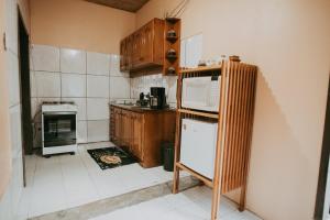 a kitchen with a refrigerator and a microwave at Morada perto dos Canyons e Balões - Rosa dos Canyons in Praia Grande