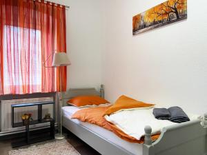 sypialnia z łóżkiem z pomarańczową i białą pościelą w obiekcie Soba za goste Kraljica 3 w mieście Kupres