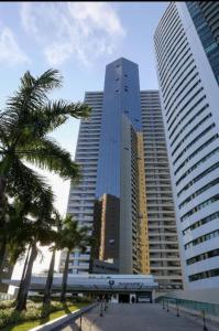 a group of tall buildings in a city with palm trees at BEACH CLASS INTERNACIONAL FRENTE MAR in Recife