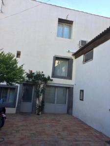 une maison blanche avec des fenêtres et une allée. dans l'établissement Castel&Letti, à Agde