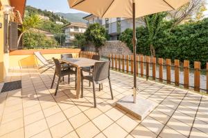 a table and chairs with an umbrella on a patio at Casa Doppia in Nago-Torbole