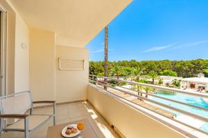 balcón con vistas a la piscina y a las palmeras en Hotel Rosella affiliated by Intelier, en Sa Coma