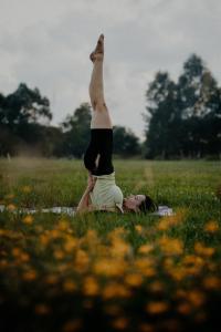 Ein Mann liegt im Gras, neben ihm ein Mann, der eine Yoga-Pose einnimmt. in der Unterkunft Szczere Pole in Karpacz