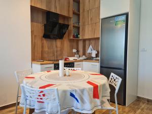 a kitchen with a table and a refrigerator at Teal Apartment in Draç