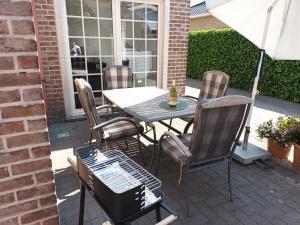 een tafel en stoelen op een patio met een parasol bij Kanaalzicht21 in Hasselt