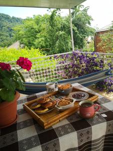 a picnic table with a tray of food and flowers at KOTE.GE in Lagodekhi