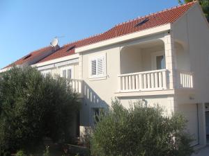 a white house with a balcony and trees at Apartments Valeria in Korčula