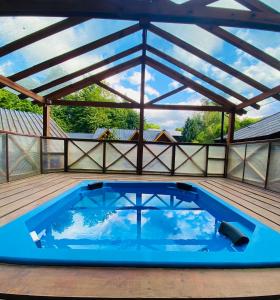 a large swimming pool on a deck with a roof at Villa Cümen in San Martín de los Andes